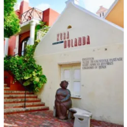 O Museu Kurá Hulanda em Curaçao, inaugurado em abril de 1999, é um museu antropológico especializado no comércio de escravos no Atlântico. Criado por Jacob Gelt Dekker, o museu ocupa 15 edifícios restaurados no cais ocidental de Otrobanda. Focando na história desde a captura na África até a realocação nas Américas, o museu destaca a herança cultural dos escravos em Curaçao e no Caribe. Ele retrata a rotina e vida dos escravos, mostrando as mudanças na população da ilha ao longo do tempo. O acervo inclui fotos, quadros, objetos da época e instrumentos musicais, oferecendo uma perspectiva abrangente desse triste período da história mundial, com ênfase na relevância do porto de Willemstad como um importante ponto de comércio de escravos na América do Sul.