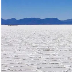 O Salar de Uyuni, o maior deserto de sal do mundo, abrange 10.582 km² a uma altitude de 3.656 metros na Bolívia. Resultado de transformações de lagos pré-históricos, sua crosta de sal serve como fonte de cobre e uma piscina de salmoura rica em lítio. Com 50-70% das reservas mundiais de lítio, é essencial na calibração de sensores de satélites. Além de ser via de transporte no Altiplano, abriga flamingos cor-de-rosa no verão e diversas espécies de aves. A região tem flora escassa, dominada por cactos gigantes, e é um destino turístico notável, especialmente entre abril e novembro, quando se torna um deserto seco. A lenda local sugere que o salar foi formado pelas lágrimas da divindade Tunupa.