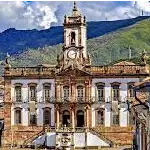 Ouro Preto é uma cidade histórica localizada no estado de Minas Gerais, no Brasil. Fundada no final do século XVII, a cidade é conhecida por sua rica história ligada à exploração do ouro durante o período colonial. Foi um importante centro econômico e político no auge do ciclo do ouro no Brasil. A cidade abrigava diversos engenhos de mineração e atraiu uma grande quantidade de pessoas em busca de riqueza. Com o declínio da exploração do ouro, Ouro Preto passou por um período de estagnação econômica, o que ajudou a preservar sua arquitetura colonial. Além das igrejas, Ouro Preto abriga diversos museus que contam a história da região, como o Museu da Inconfidência, que homenageia os líderes da Inconfidência Mineira, movimento de independência ocorrido no século XVIII. 

