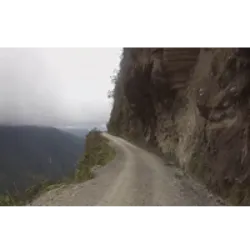 O Caminho a Los Yungas, conhecido como "Caminho da Morte", é uma perigosa estrada boliviana de 64 km que liga La Paz à região de Los Yungas. Famosa por sua estreiteza e periculosidade, registra em média 209 acidentes e 96 mortes anualmente, atraindo ciclistas aventureiros. A região de Los Yungas é histórica e culturalmente significativa, desempenhando um papel na produção de coca, planta sagrada na Bolívia. A coca permanece legal no país, apesar das restrições globais à cocaína. A área também tem uma história relacionada à "corrida do ouro" com mineração ilegal, associada ao crime organizado e impactos ambientais. Coroico, uma antiga cidade mineradora de ouro, é agora uma base turística para explorar a biodiversidade e tradições agrícolas das Yungas, marcando uma transição entre os Andes e a Amazônia.